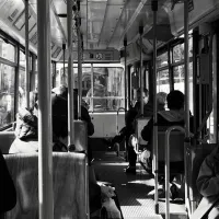 Photo by Alan Fung on Unsplash en noir et blanc d'usagers d'un bus