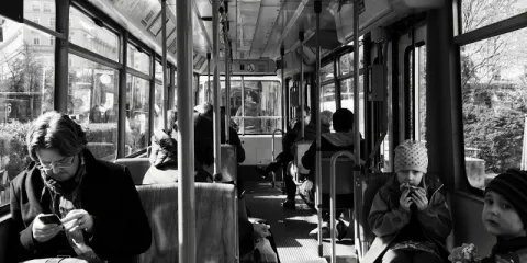 Photo by Alan Fung on Unsplash en noir et blanc d'usagers d'un bus