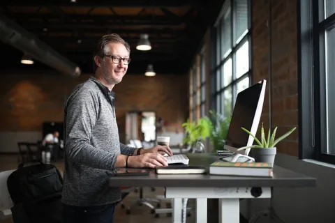 un homme travaillant sur son bureau avec une plante