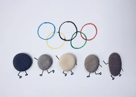 sigle des jeux olympiques avec des petits bonshommes en pierre